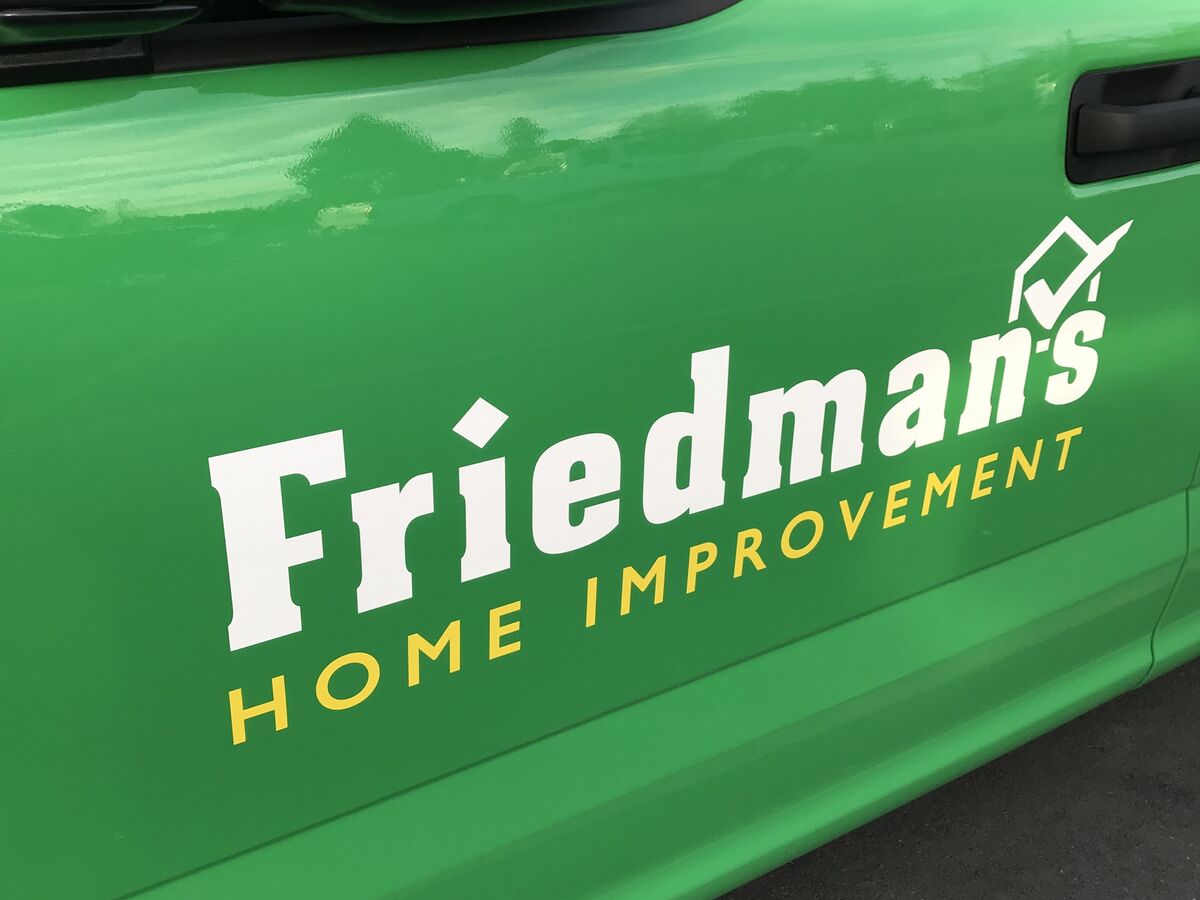 Close view of a green truck door carrying the Friedman's Home Improvement wordmark in cut white vinyl